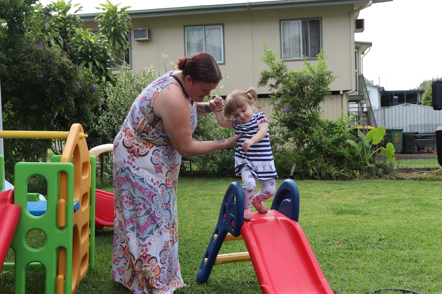 A mother and toddler playing on a slide