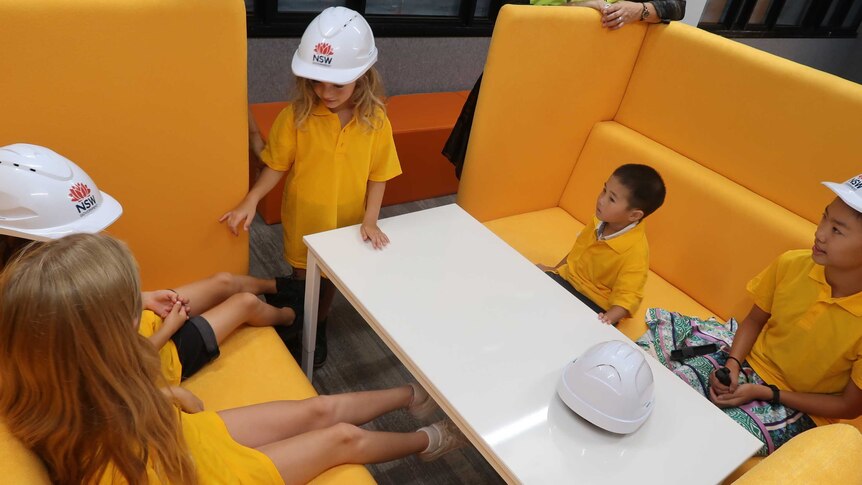 Children sit on yellow lounges