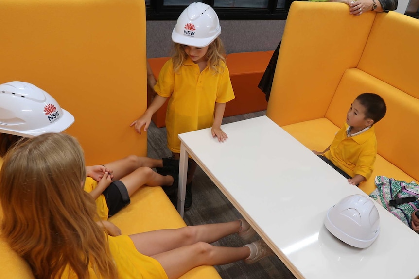 Children sit on yellow lounges