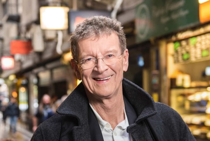 ABC broadcaster Red Symons smiling in an alleyway