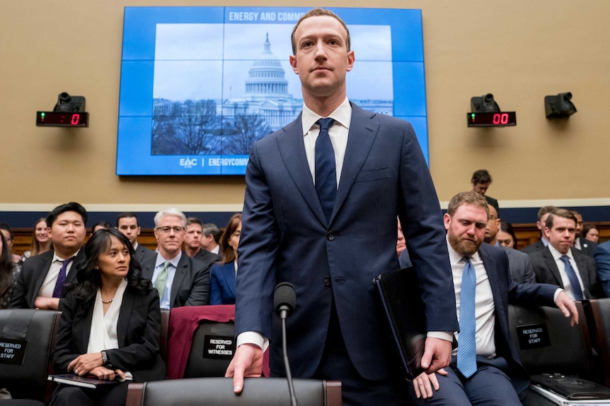 Facebook CEO Mark Zuckerberg arrives to testify on Capitol Hill. He is wearing a blue suit.