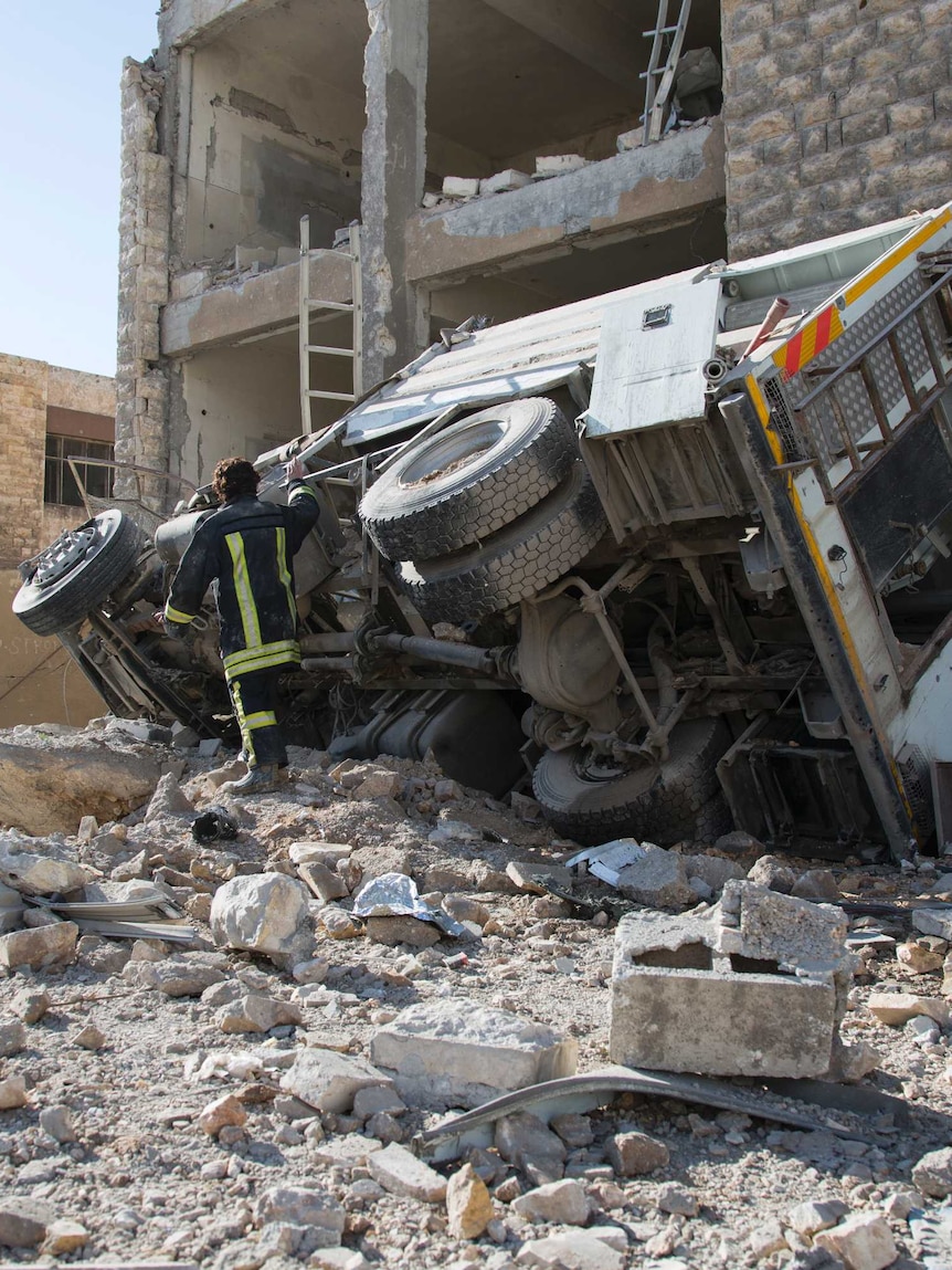 A Syrian man checks the damage following air strikes