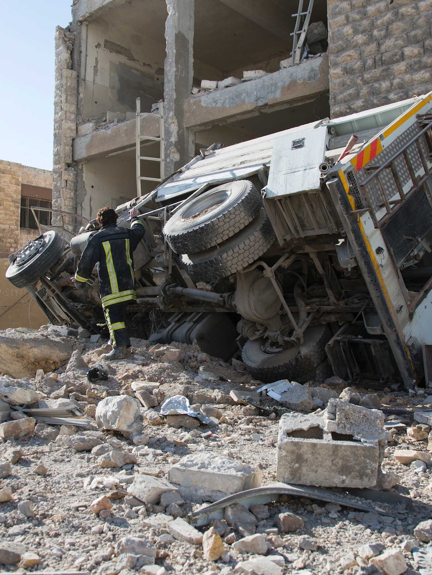 A Syrian man looks at a heavily damaged building following air strikes on rebel-held eastern areas of Aleppo.