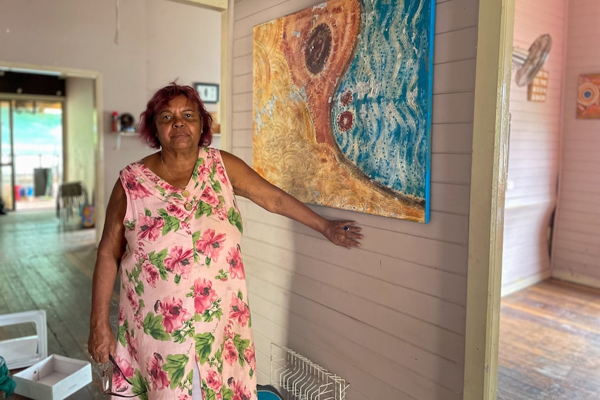 a woman standing indoors holding onto a wall