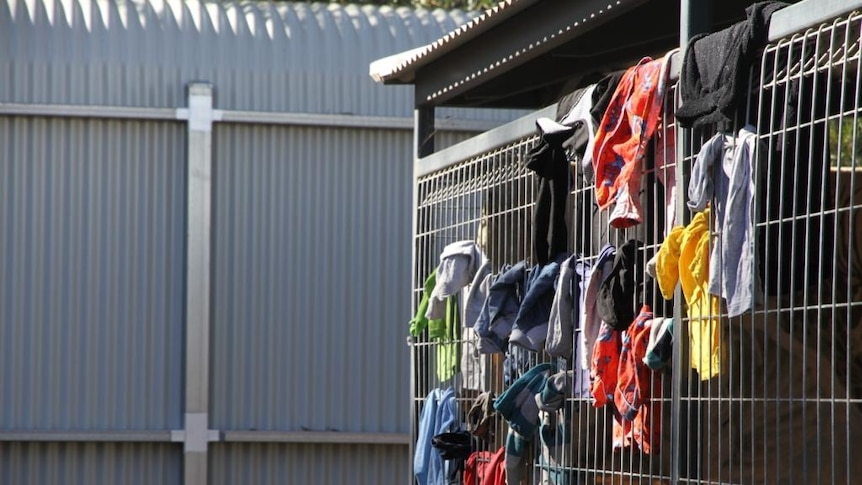 Shirts hanging on cage in Alice Springs homeless shelter.