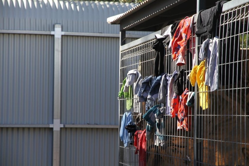 Shirts hanging on cage in Alice Springs homeless shelter.