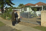 Bernie King and David Marochhi looking at Mr King's brick home from the street.