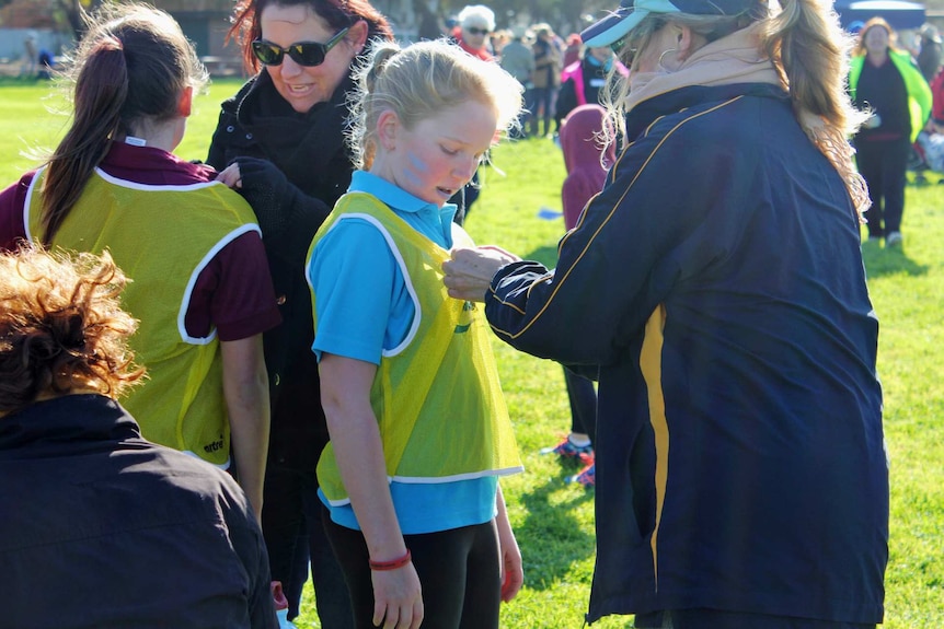 The winning ribbon pinned to a young winner at the School of the Air athletics carnival.