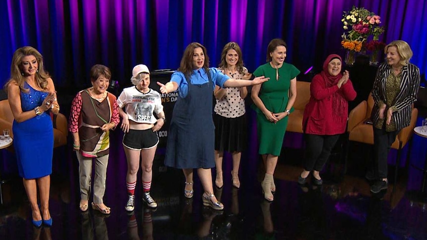 A group of women stand on a TV stage