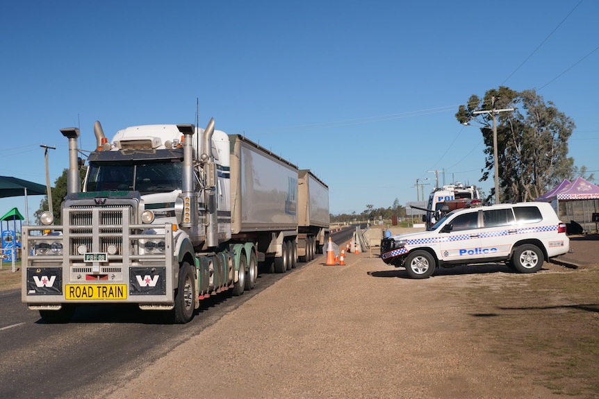 A truck is driving past a border checkpoint in outback QLD.