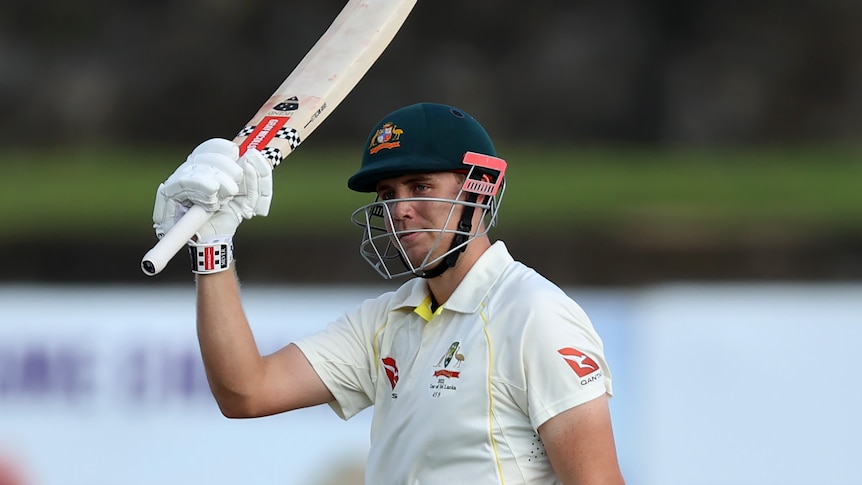 A man celebrates a half century during a cricket match