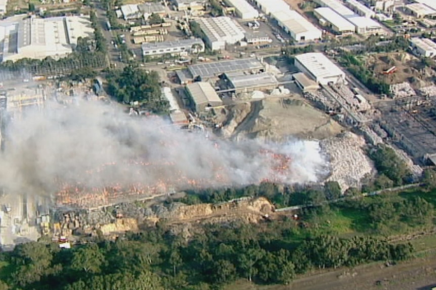Smoke pours out the Coolaroo tip fire, seen from the air.