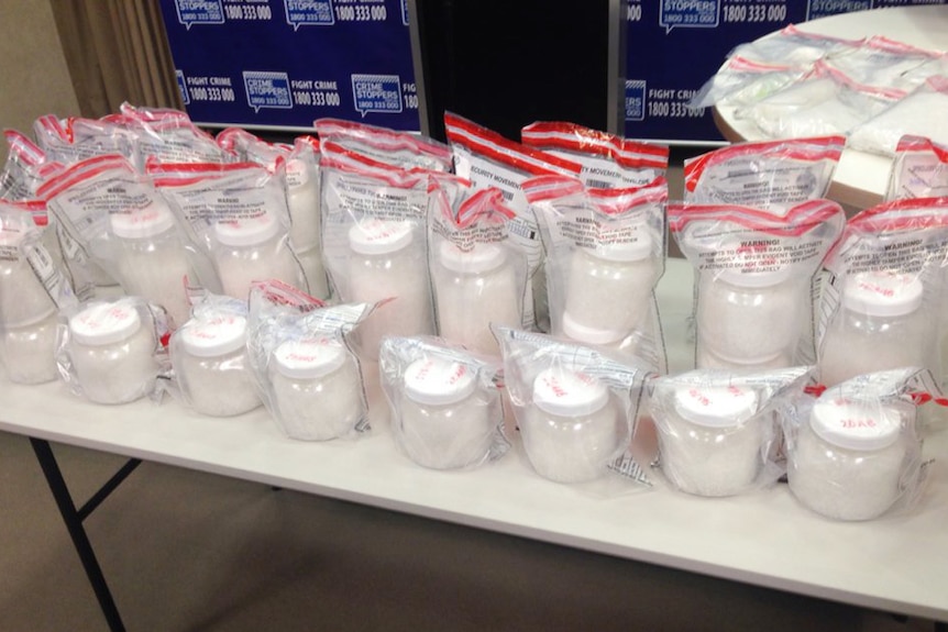 Around 20 sealed bags containing jars of methamphetamines sit on a table at WA Police headquarters.