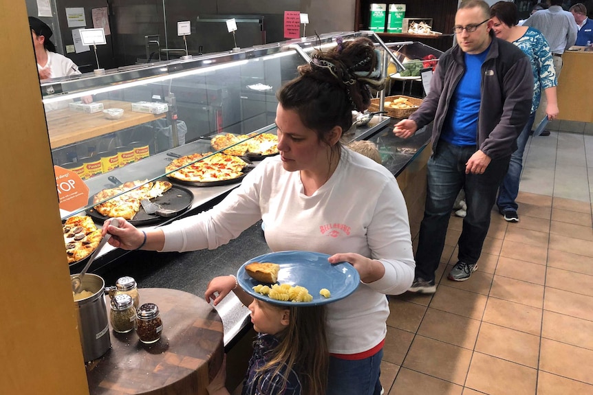 Rachel Malcom gathers food for her and her daughter in Bristol, Rhode Island