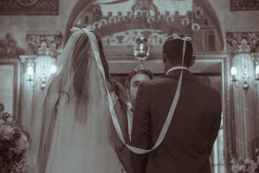 Eleni and Chris wearing Orthodox wedding tiaras