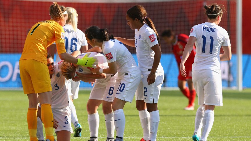 Laura Bassett is consoled by teammates after own goal