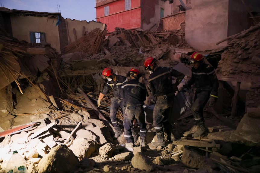Emergency workers work through dust and debris 
