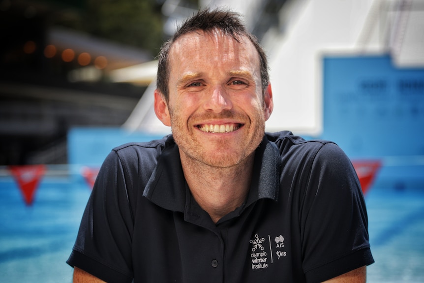 A man in a blue shirt smiling.