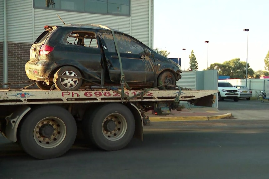 wreck of a small car on a tow truck