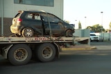 Wreck of a small car on a tow truck.