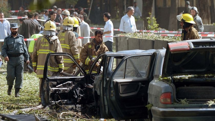 Security personnel inspect a bombed car