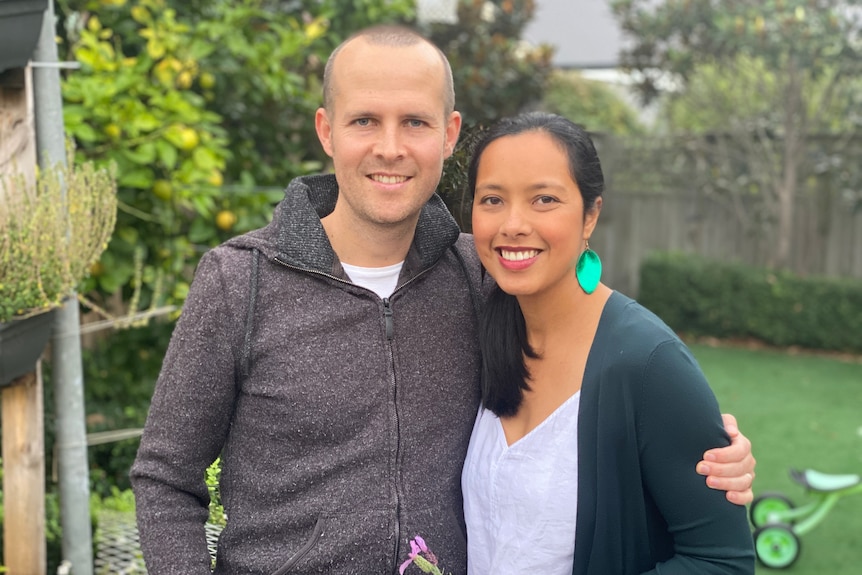 A man and woman smile at the camera.