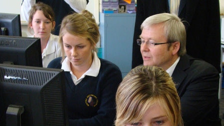 Rudd sits with high school students at computers