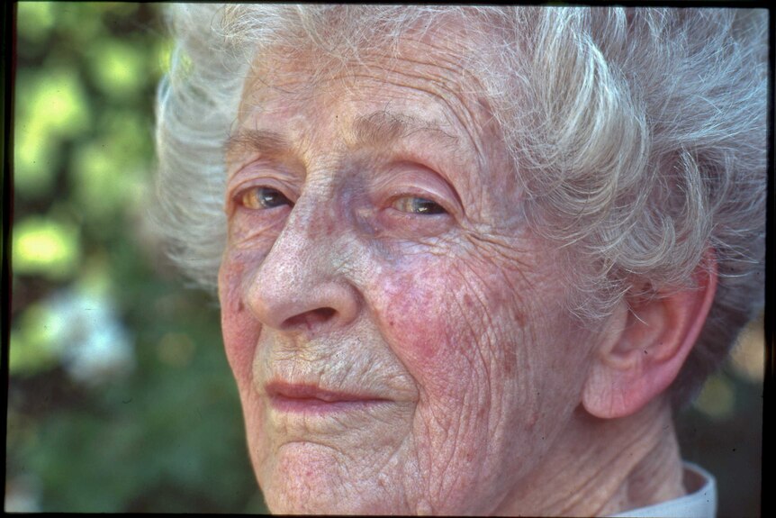 A close up of an elderly women with wise eyes and short white hair.
