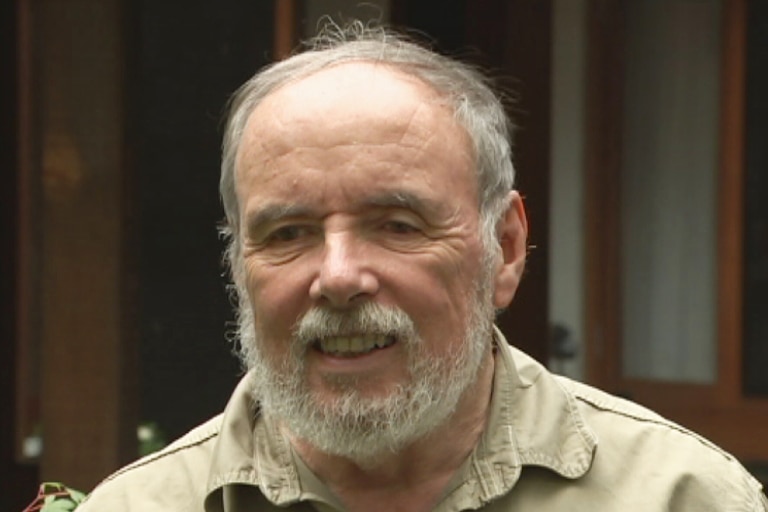 Ian McAuley stands outside his home.