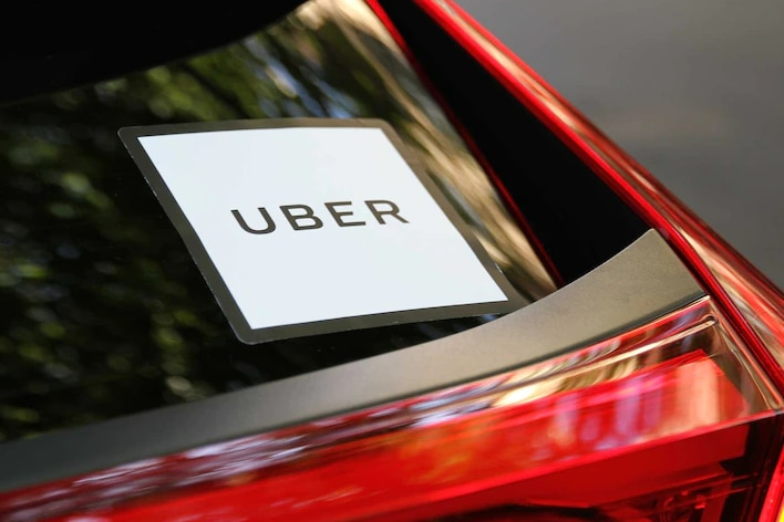 Un autocollant Uber sur la vitre arrière d'une voiture rouge