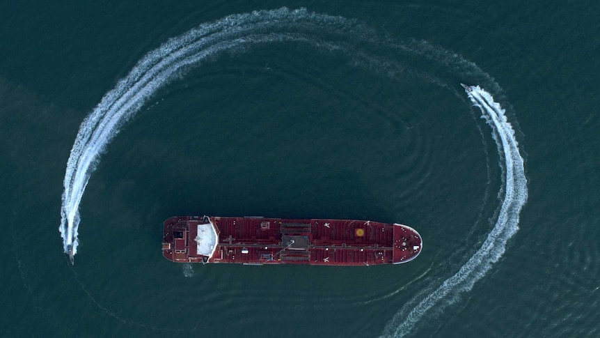 An aerial view shows a speedboat of Iran's Revolutionary Guard moving around a British-flagged oil tanker.