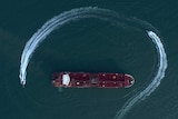 An aerial view shows a speedboat of Iran's Revolutionary Guard moving around a British-flagged oil tanker.