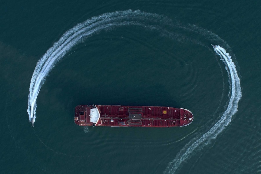 An aerial view shows a speedboat of Iran's Revolutionary Guard moving around a British-flagged oil tanker.