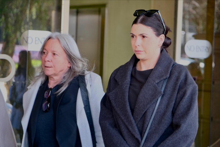 Lauren Willgoose walks alongside an older woman outside the court