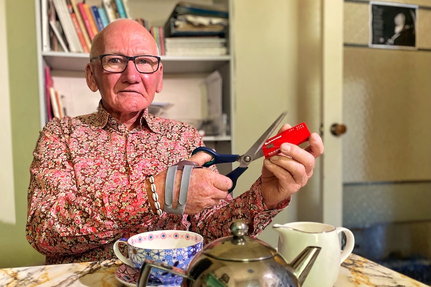 Qantas customer Geoff Goodfellow cuts up his frequent flyer card.