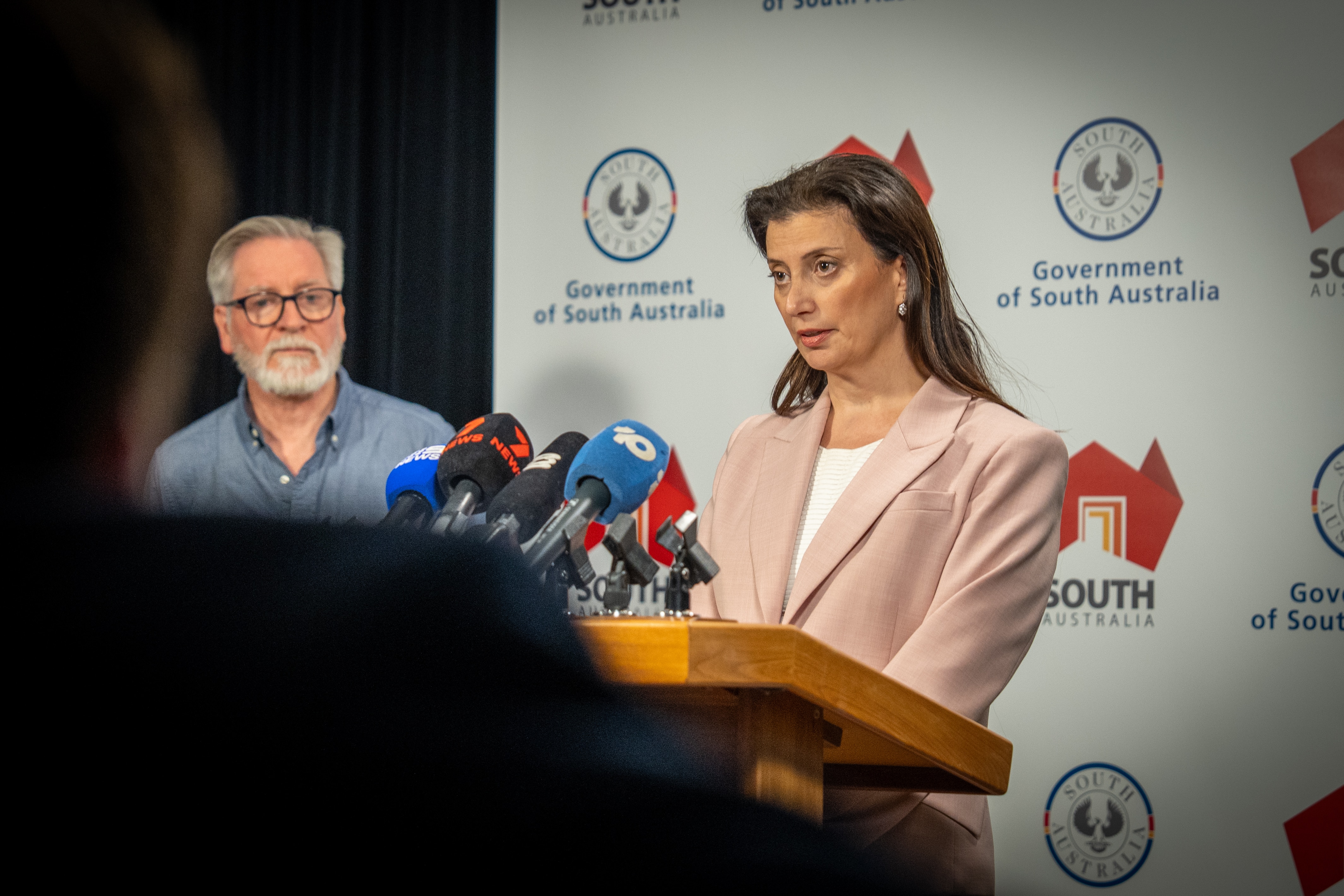 Un sacerdote habla frente a un atril con muchos micrófonos