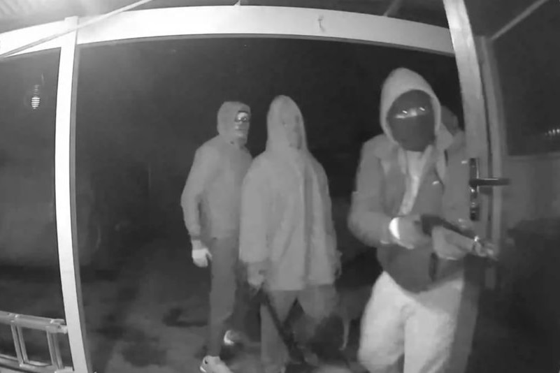 CCTV footage shows three men trying to break into a home at night.