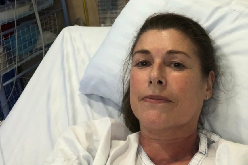 a woman in a hospital bed taking a selfie