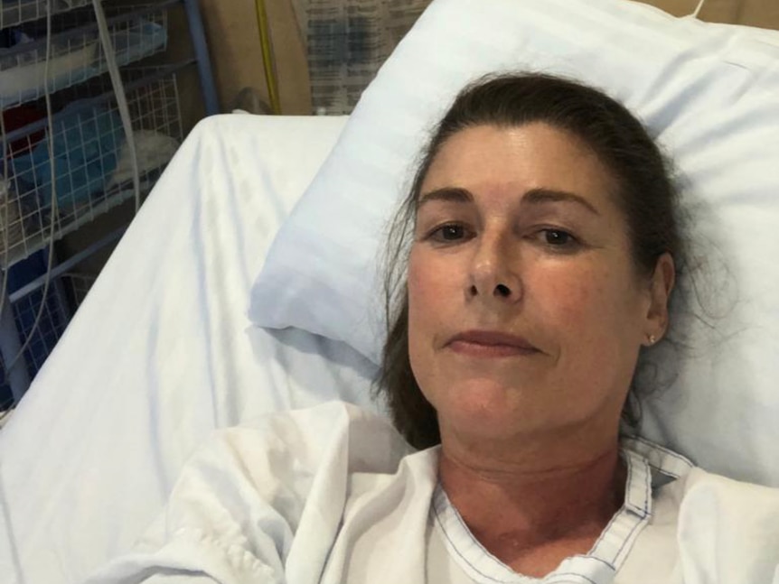 a woman in a hospital bed taking a selfie