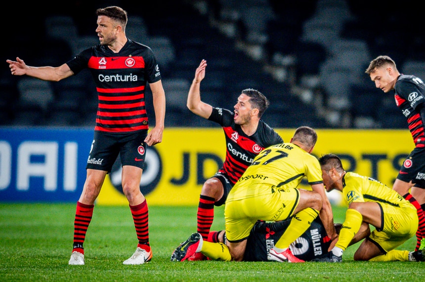 A-League players gesture with their hands for medical attention for their teammate on the ground.