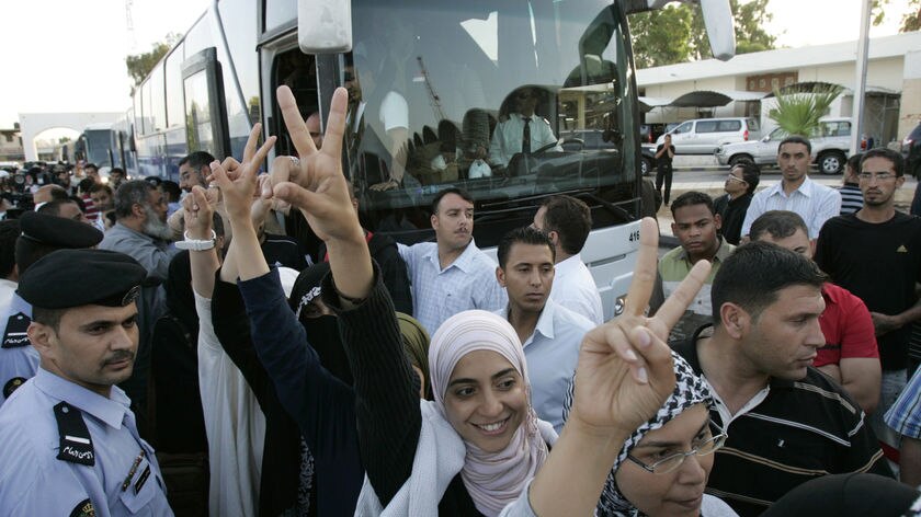 Activists, seized during a raid on an aid convoy sailing to Gaza, gesture as they arrive in Jordan