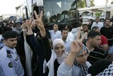 Activists, seized during a raid on an aid convoy sailing to Gaza, gesture as they arrive in Jordan