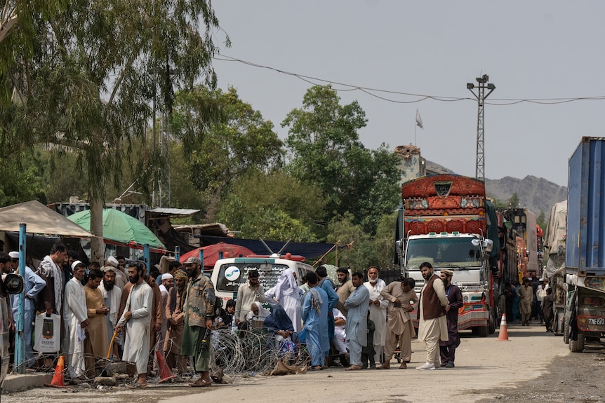 People line up in the foreground, with a decorated truck in the background. 