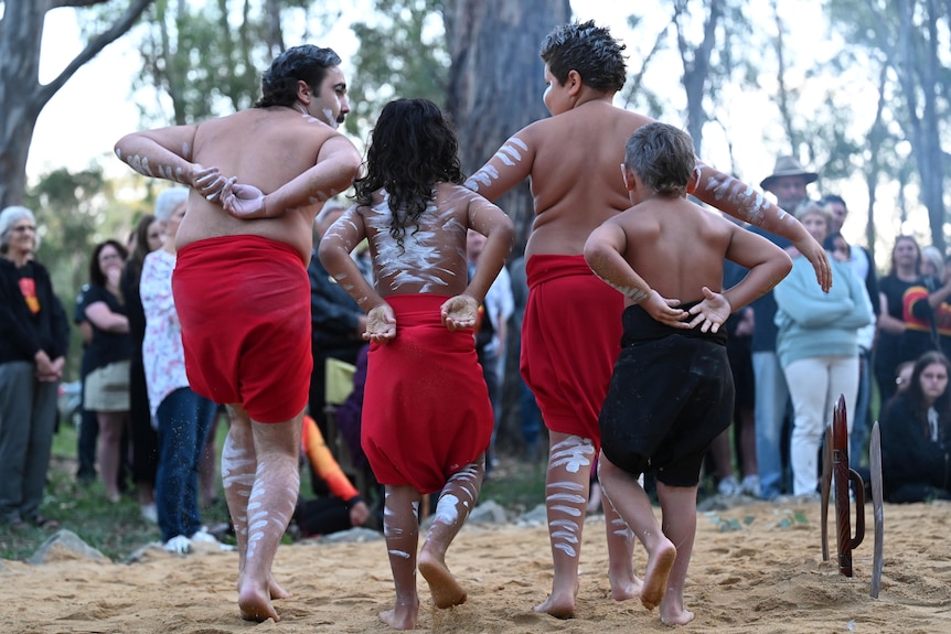 Four Indigenous men dance