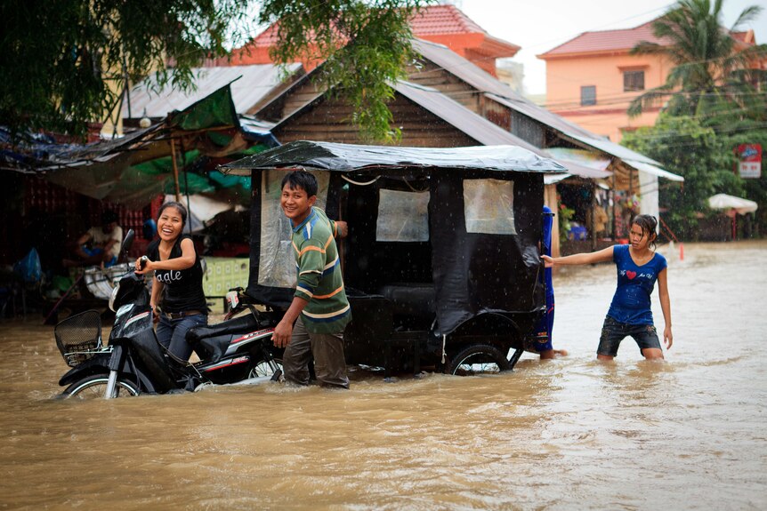 A family push their tuk-tuk through floodwaters in Siem Reap in late September, 2011.