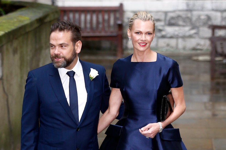 A man in a suit and a woman in a blue dress