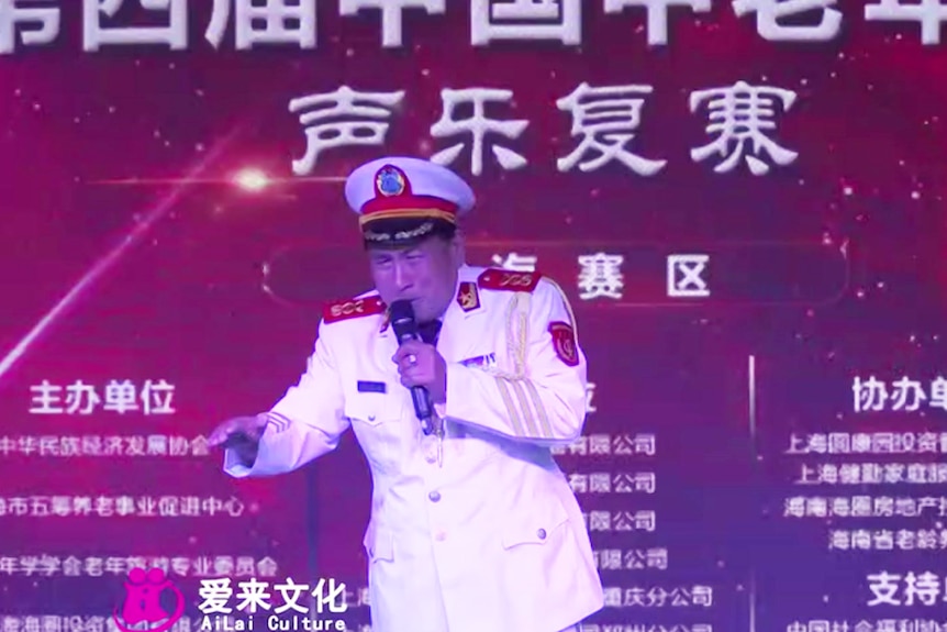 A man in uniform appears to sing on stage.
