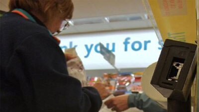 A woman receiving change at a supermarket checkout