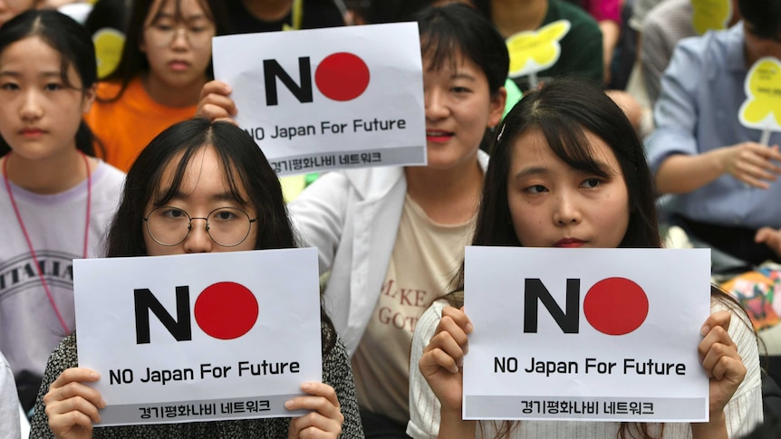 Women hold anti-Japanese signage reading 'No Japan for future.'