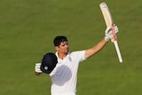 England's Alastair Cook holds a cricket bat in the air in celebration.